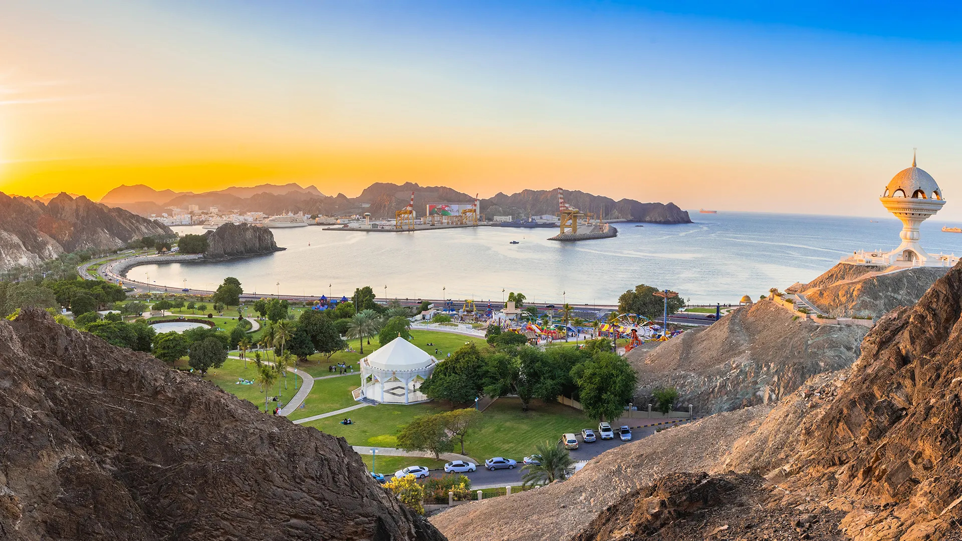 La baie de Mascate au coucher du soleil, entre les montagnes du Hajar et la mer